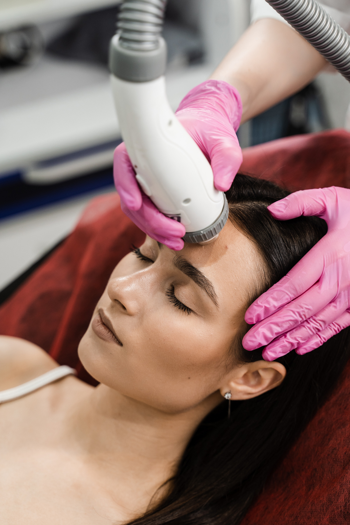 Radio frequency lifting for young woman. Dermatologist is doing radio frequency RF skin tightening. RF facelift firms and lifts sagging skin.